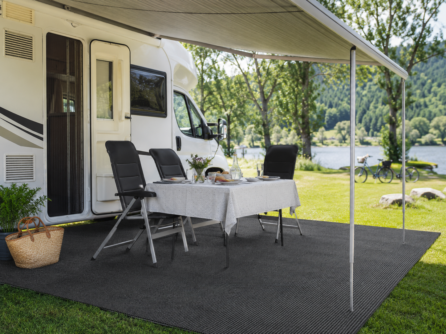 Tent tapijt op rol als ondergrond naast een camper